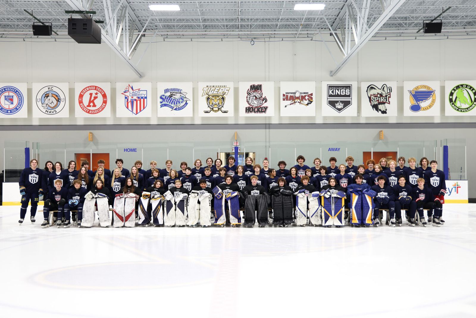 Full academy class photo on the ice with club banners