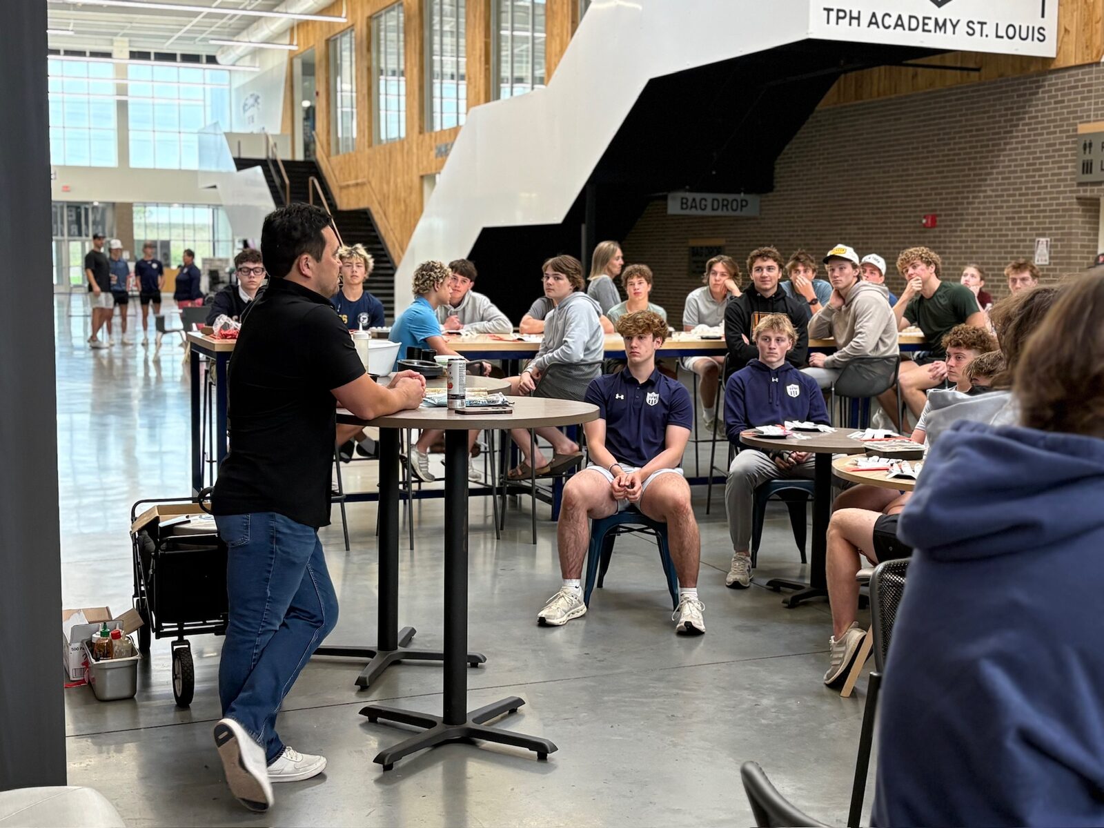 Students working at high-top stations in the academic wing