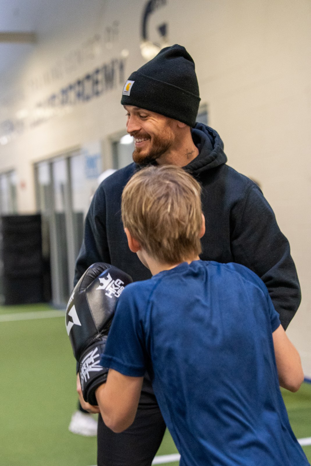 Coach mentoring a student through boxing pad work